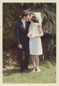 an old photo of a man and woman in formal wear standing next to each other