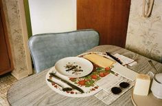 a plate with cheese on it sitting on top of a table next to a cup and saucer