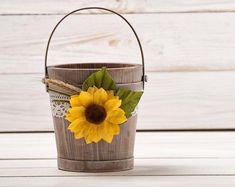 a wooden bucket with a sunflower in it