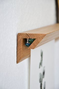 a close up of a wooden shelf with an object in it's corner on the wall