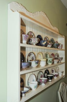 an old china cabinet with plates and bowls on it's shelves in a dining room