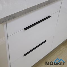 a white cabinet with two black handles on it