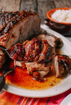 a white plate topped with meat covered in sauce