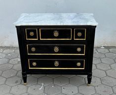 a black and gold dresser with marble top