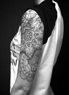 black and white photo of a man's half sleeve tattoo with flowers on it