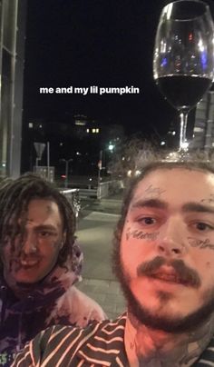 two men standing next to each other in front of a wine glass on the street