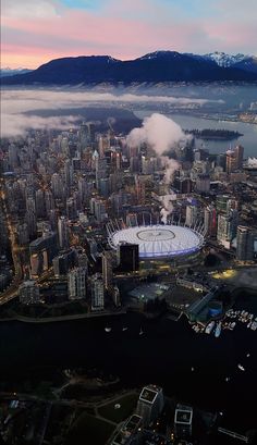 an aerial view of the vancouver olympic stadium and surrounding city buildings with mountains in the background