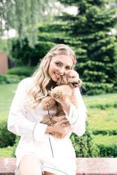 a woman sitting on a bench holding a dog