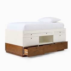 a bed with two drawers underneath it and a white blanket on top of the bed