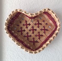 a heart shaped basket hanging on the wall