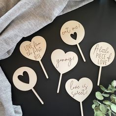 four heart shaped wooden picks with the words love is sweet on them