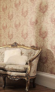 an old fashioned couch sitting in front of a wall