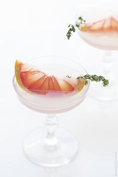 an orange slice sitting on top of a glass filled with liquid and garnish