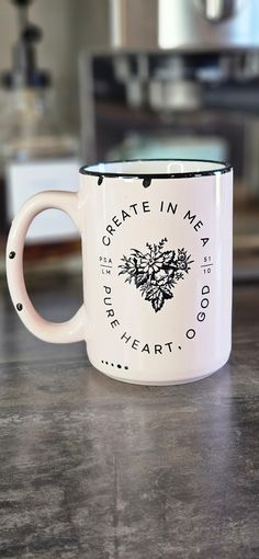 a white coffee mug with the words create in me on it sitting on a counter