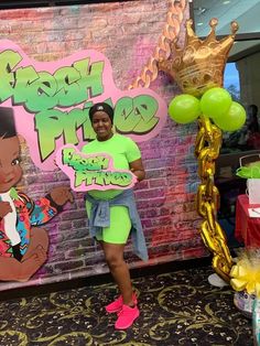 a woman standing in front of a brick wall holding a sign that says happy birthday