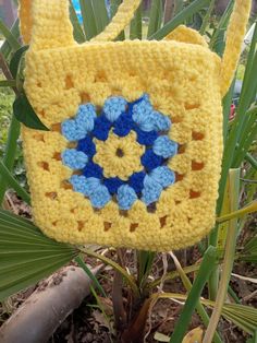 Bright yellow  handmade purse. Both sides are identical with a blue flower pattern and a thick crossbody strap. No lining, all acrylic yarn. Machine washable and dryer safe! Body is 6 inches by 6 inches. Strap is 38 inches by 1 inch. Yellow Crochet Rectangular Shoulder Bag, Yellow Crochet Rectangular Bag, Handmade Yellow Crochet Bag For Gift, Yellow Crochet Bag For Everyday Use, Yellow Granny Square Crochet Bag, Blue Flower Pattern, Flower Purses, Handmade Purse, Handmade Purses