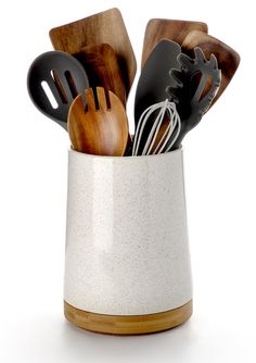 a cup filled with utensils and wooden spoons