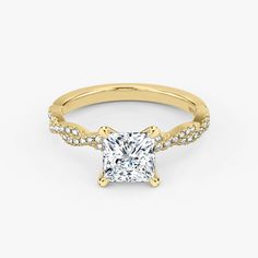 a yellow gold engagement ring with a princess cut diamond and pave set diamonds on the band