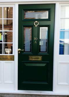 a green front door with two windows