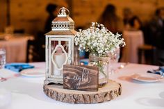 a wooden table topped with a vase filled with white flowers and a sign that says joy