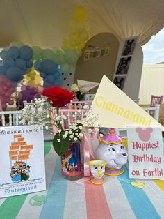 there is a birthday party set up on the table with balloons and flowers in vases