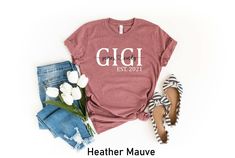 a t - shirt that says gigi est 2021 next to some flowers and shoes