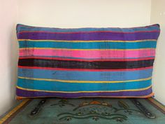 a colorful striped pillow sitting on top of a table