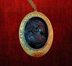 This is a gorgeous black glass cameo set in a very ornate brass finish metal frame. I date this to somewhere around 1940's or 1950's.   The cameo is very 3-dimensional.  This is quite a statement piece!   It comes on a gold tone 24-inch chain with a clasp. The cameo alone is 36 x 47 mm.  The entire piece measures 2 x 2 5/8 inches. The cameo is in excellent condition.  No chips or scratching. Some light dust in the crevices. The chain is in excellent condition. Thank you for taking the time to visit my shop and for supporting my small business. The Black Cat Closet is a one-woman operation that has been around since 1999. Please do not hesitate to contact me with any questions. Take a look at more of my unique Vintage and handmade items by following this link: https://www.etsy.com/shop/theb Black Cameo Necklace In Vintage Style, Vintage Black Jewelry With Antique Finish, Vintage Black Cameo Necklace, Vintage Black Cameo Jewelry, Black Cameo Jewelry For Collectors, Collectible Black Cameo Jewelry, Cat Closet, Custom Bar Necklace, Stick Family