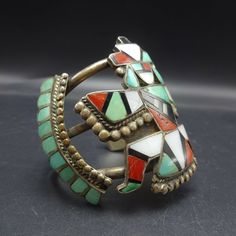 "VINTAGE ZUNI KNIFEWING BRACELET circa 1940s DESCRIPTION: This exquisite bracelet dates from the late 1930s to 1940s. Possibly created by Frank or Homer Vacit, the knifewing kachina features flat channel inlay of turquoise, coral, jet, and mother of pearl. An abundance of applied raindrops line the inlay. This outstanding old cuff will be a cherished addition to your collection of the very finest vintage Native American jewelry. MEASUREMENTS: Interior of the cuff measures 5 1/2\" with an additio Vintage Australia, Jewelry Measurements, Bones Bracelet, Vintage Native American Jewelry, Zuni Jewelry, American Indian Jewelry, Sterling Silver Charm Bracelet, Turquoise Bracelet Cuff, Turquoise Cuff