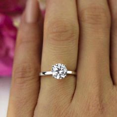 a woman's hand with a diamond ring on it