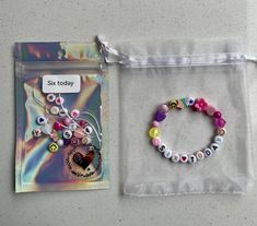 a bag with some beads on it next to a card and a beaded bracelet