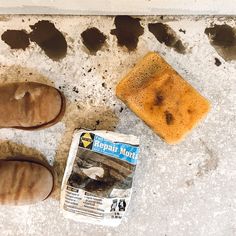 a pair of brown slippers next to a soap bar on the ground with holes in it