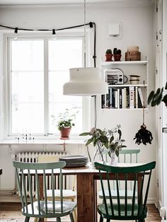 two green chairs sitting at a table in front of a window