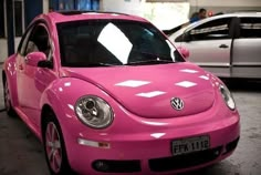 a pink vw bug parked in a garage