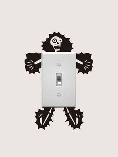 a light switch cover with a skull and crossbones design on the front side