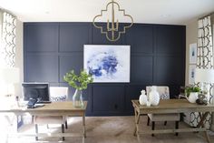 a living room filled with furniture and a chandelier hanging from the ceiling over a wooden table