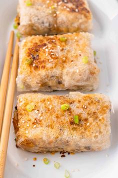 some food on a white plate with chopsticks