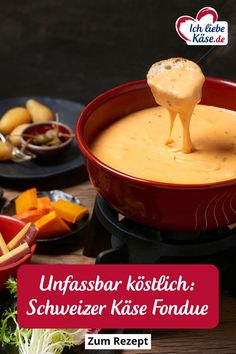 a red bowl filled with cheese sauce on top of a table next to other food