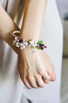 a woman wearing a bracelet with flowers on it