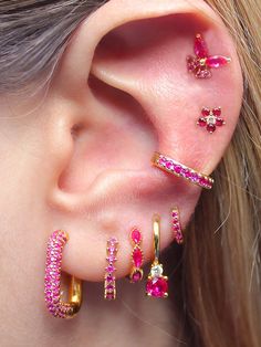 a woman wearing ear piercings with pink stones