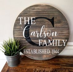 a wooden sign that says the carbon family established 1934 on it next to a potted plant