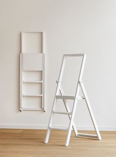 a white ladder leaning against a wall next to a book shelf in an empty room