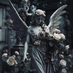 an angel statue with flowers in front of it