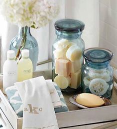 a tray filled with soaps and other bathroom items on top of a counter next to a window