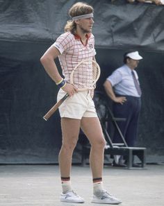 a man standing on top of a tennis court holding a racquet in his hand