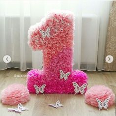 a number one made out of pink and white ruffles with butterflies around it