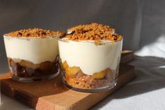 two desserts sitting on top of a wooden cutting board