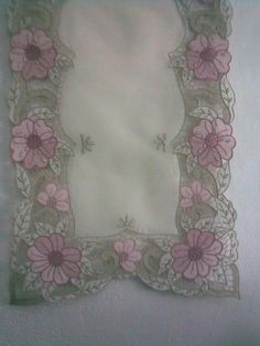 an embroidered doily with pink flowers on it