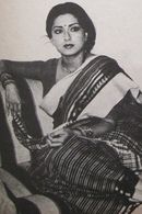 a black and white photo of a woman sitting on a chair with her hands in her pockets