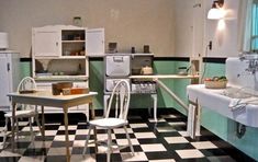 an old fashioned kitchen with black and white checkered flooring, green cabinets, and appliances